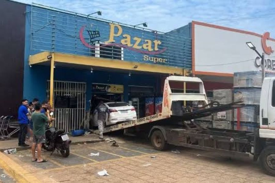 Funcionário consegue escapar poucos segundos antes de mulher invadir distribuidora com carro.